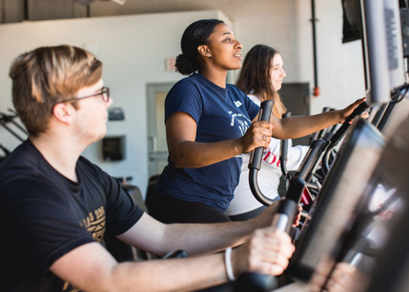 Three FDU students working out in a gym