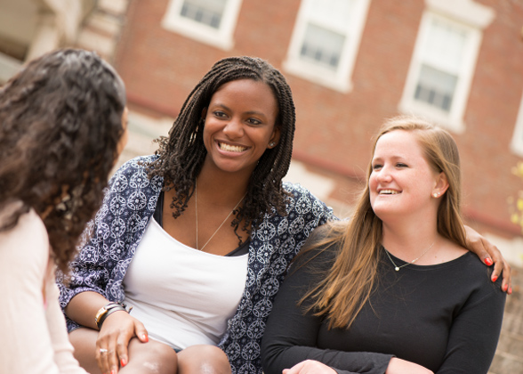Three female students sitting outside.