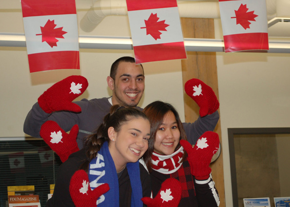 Vancouver students waving their red and white maple leaf mittens under Canadian flags